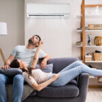 Young couple chilling on sofa looking at air conditioning in los angeles