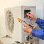 Technician in blue uniform fixing air conditioning in los angeles