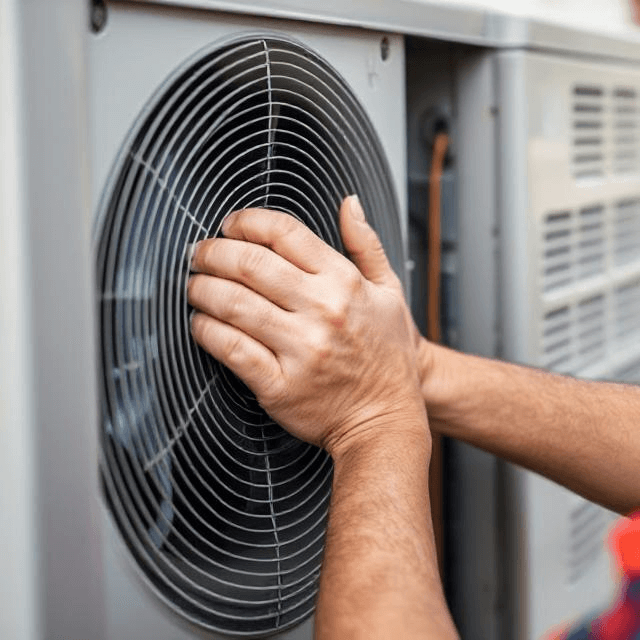 A professional HVAC technician performing an air conditioner tune-up in Van Nuys, CA. The technician is inspecting the coils and cleaning the filter to ensure optimal performance during the hot summer months.